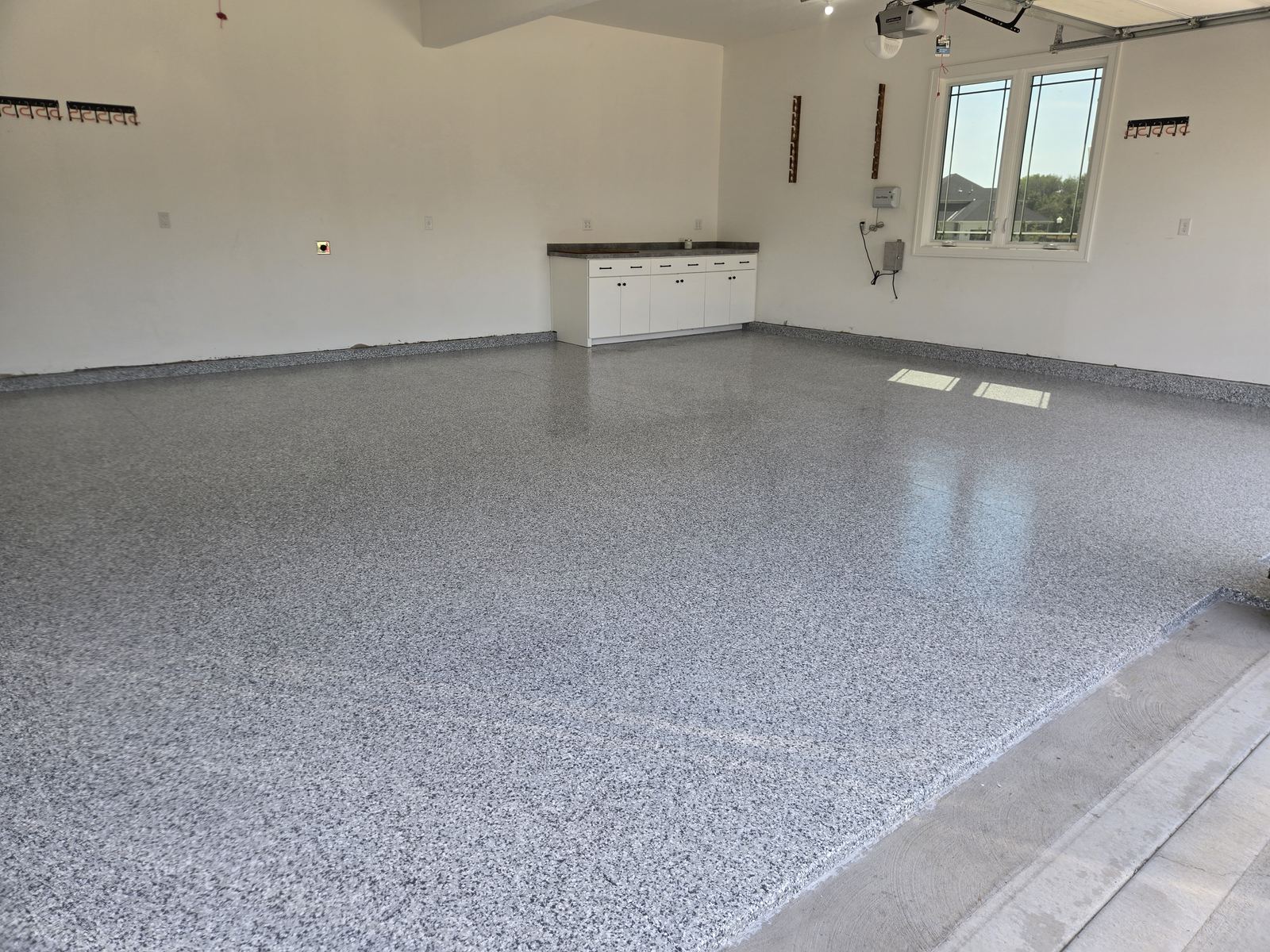 After: finished flake epoxy garage floor with a high-gloss topcoat