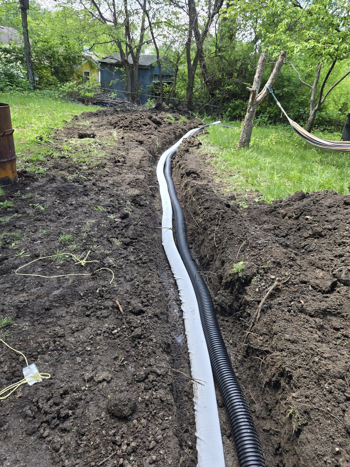 French drain pipe laid along a backyard trench