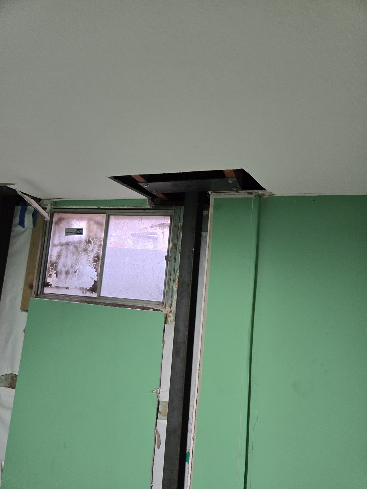 Steel I-beam bracing a basement wall