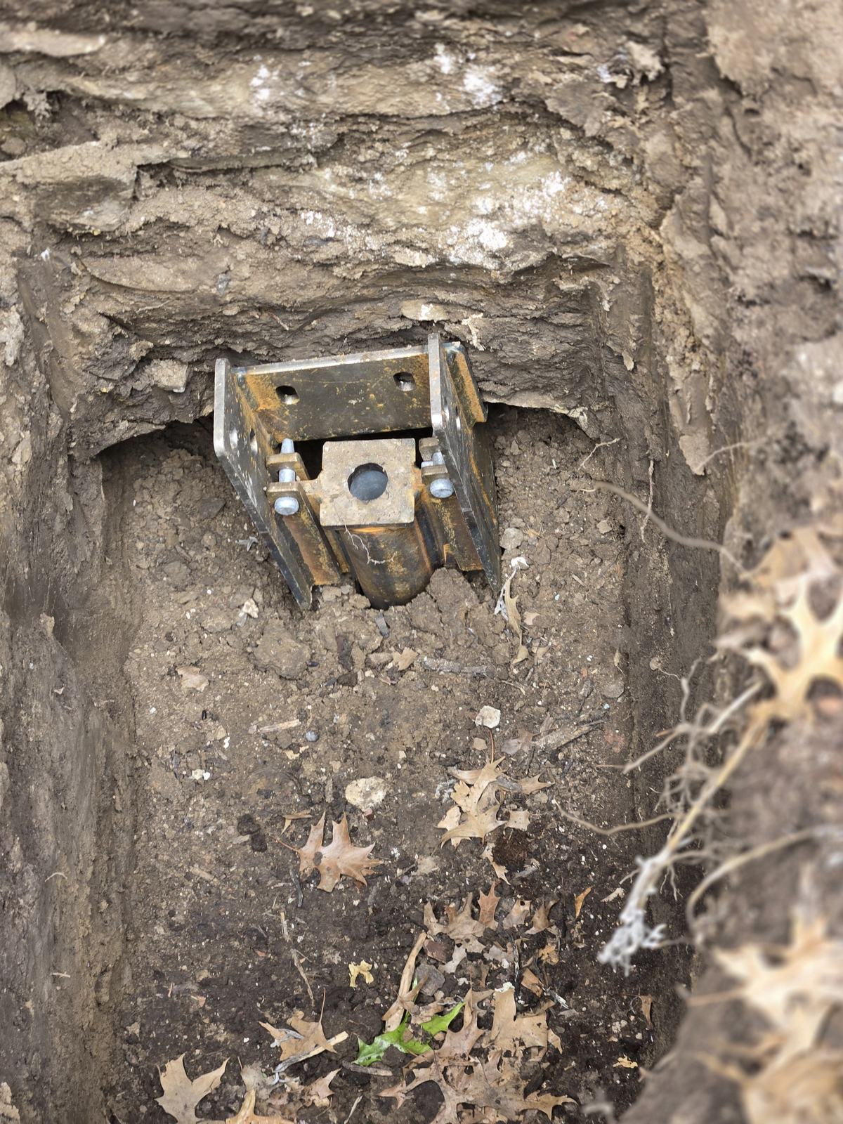 Steel push pier bracket installed at a home's footing