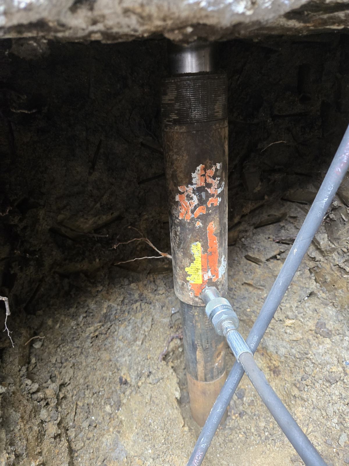 Steel pier being hydraulically driven under a footing