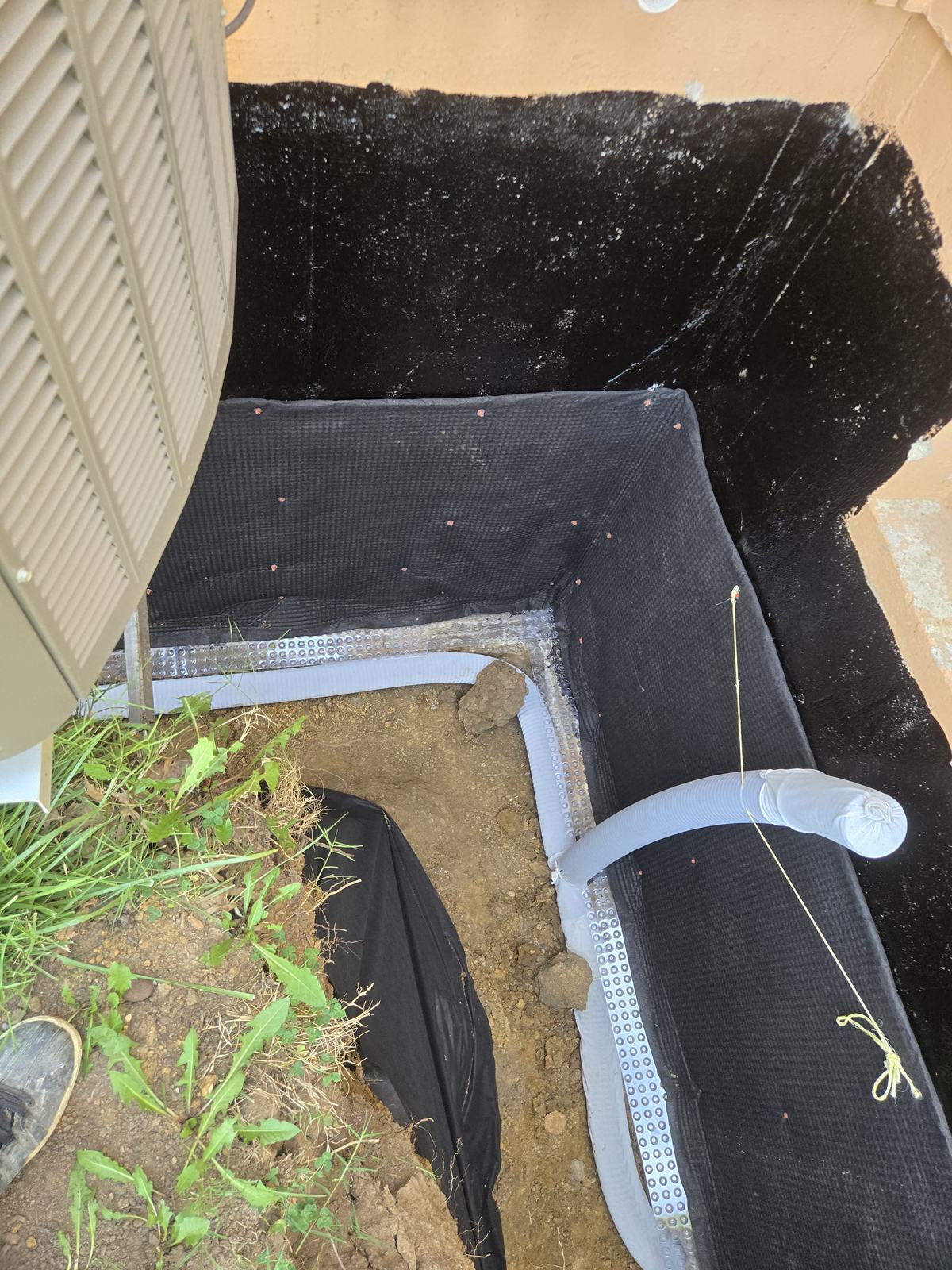 Waterproofing membrane and drain around a window well